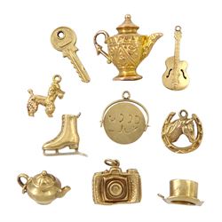Ten 9ct gold pendant/charms including poodle, horses head, ice-skate, guitar, key, top hat and good luck spinner