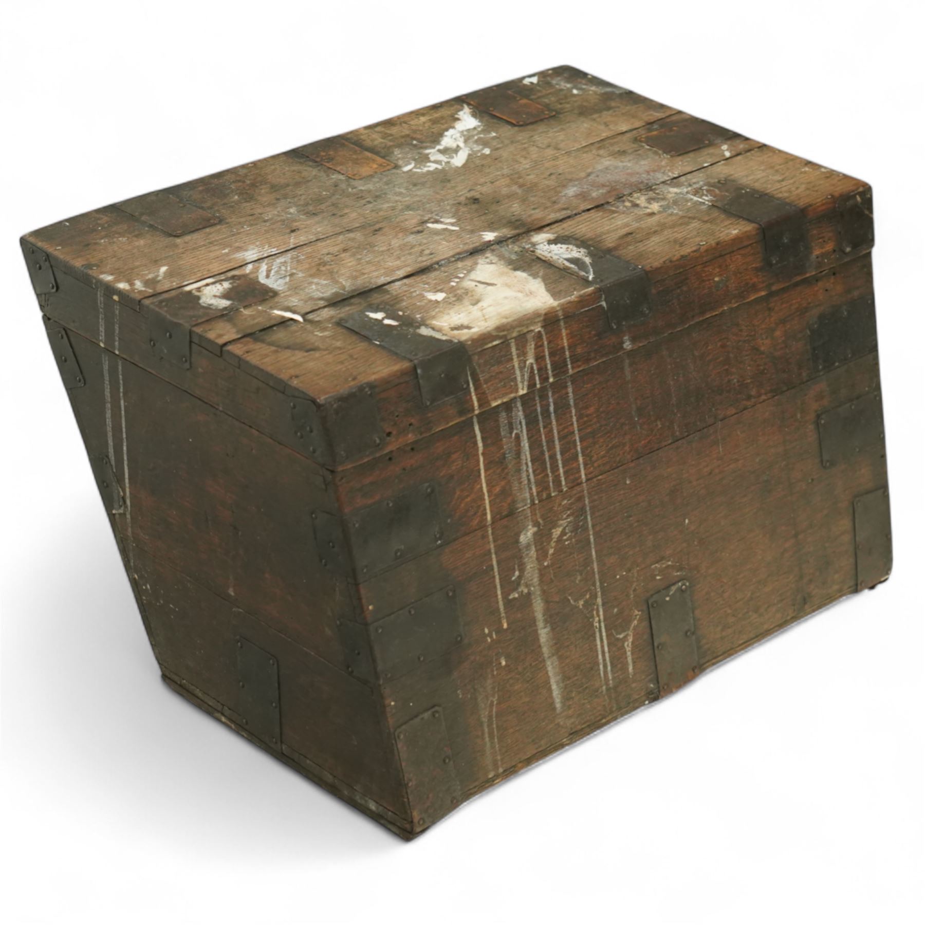 19th century metal bound ship’s trunk, of trapezoidal form with hinged lid, iron strapwork and corner reinforcements, remains of paper lining to interior