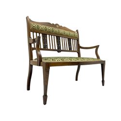Edwardian inlaid rosewood salon suite, comprising of two seater settee, armchair, and three chairs, shaped cresting rail with ivorine stringing over stick back with pierced foliate carved splats, upholstered in foliate patterned green and ivory fabric, raised on square tapering supports with spade feet