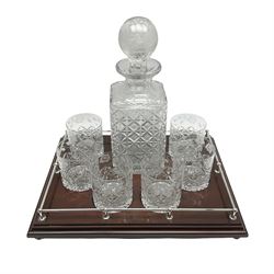 Edinburgh Crystal decanter set, comprising large square sided decanter the body with cut decoration, the globular stopper etched with roses and thistles, H32cm, six tumblers with conforming decoration, and tray with silver gallery and four silver bun feet, L40.5cm

