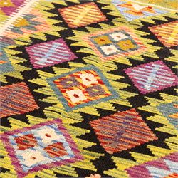 Afghan Maimana flatweave kilim, central field features large bold nested diamond motifs and stylized geometric lozenge patterns on olive purple, blue, and green tone ground, border stripe in mustard ground, and fringe