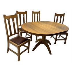 Contemporary light oak round extending dining table with four chairs, table has fold out leaf attached underneath on four out-swept legs, Oak chairs with straight top rail over twin slat back with pierced motifs, brown leather seat with brass studs, square legs joined by plain stretcher 
