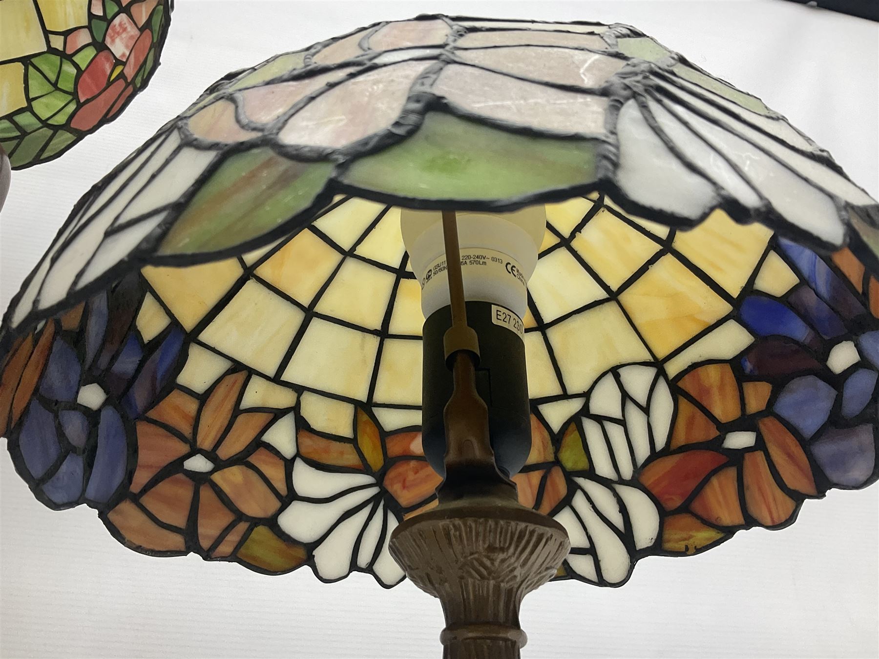 Tiffany style lamp in the form of a semi nude woman holding up a leaded lampshade together with a similar table lamp