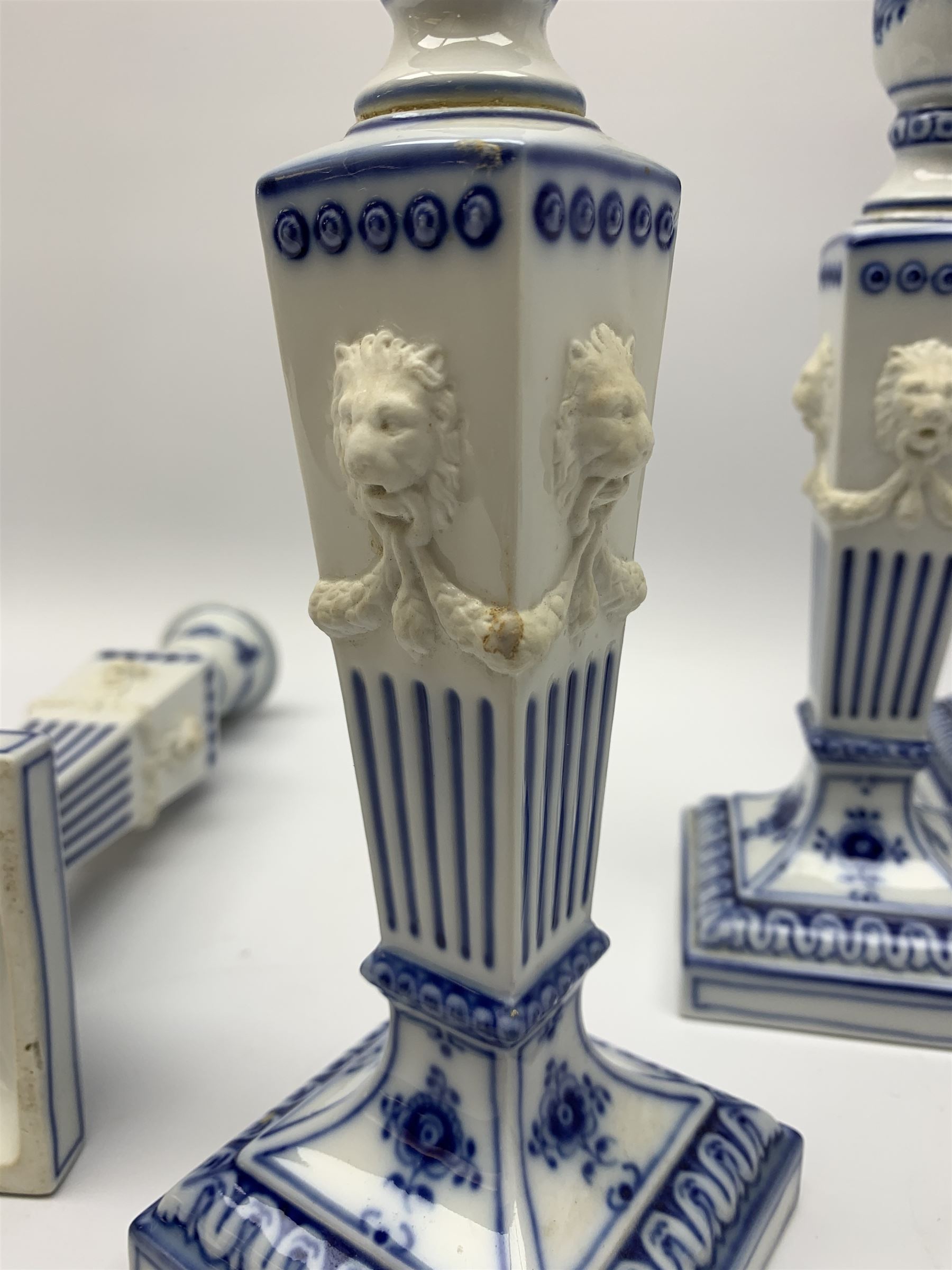 Set of four late 20th century Royal Copenhagen blue fluted candlesticks, of Neoclassical form, the tapering stems with lion masks and husk swag detail, with printed and painted marks beneath, H23cm