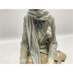 Lladro figure, Violinist, modelled as a man seated upon a  mile stone holding a violin, sculpted by Salvador Furió, no 4887,  year issued 1984, year retired 1981, H35cm