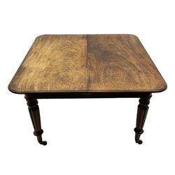 Early 19th century figured mahogany extending dining table, the rectangular top with moulded edge and rounded corners, pull-out action with three additional leaves, raised on turned and lobe carved supports with brass cup castors