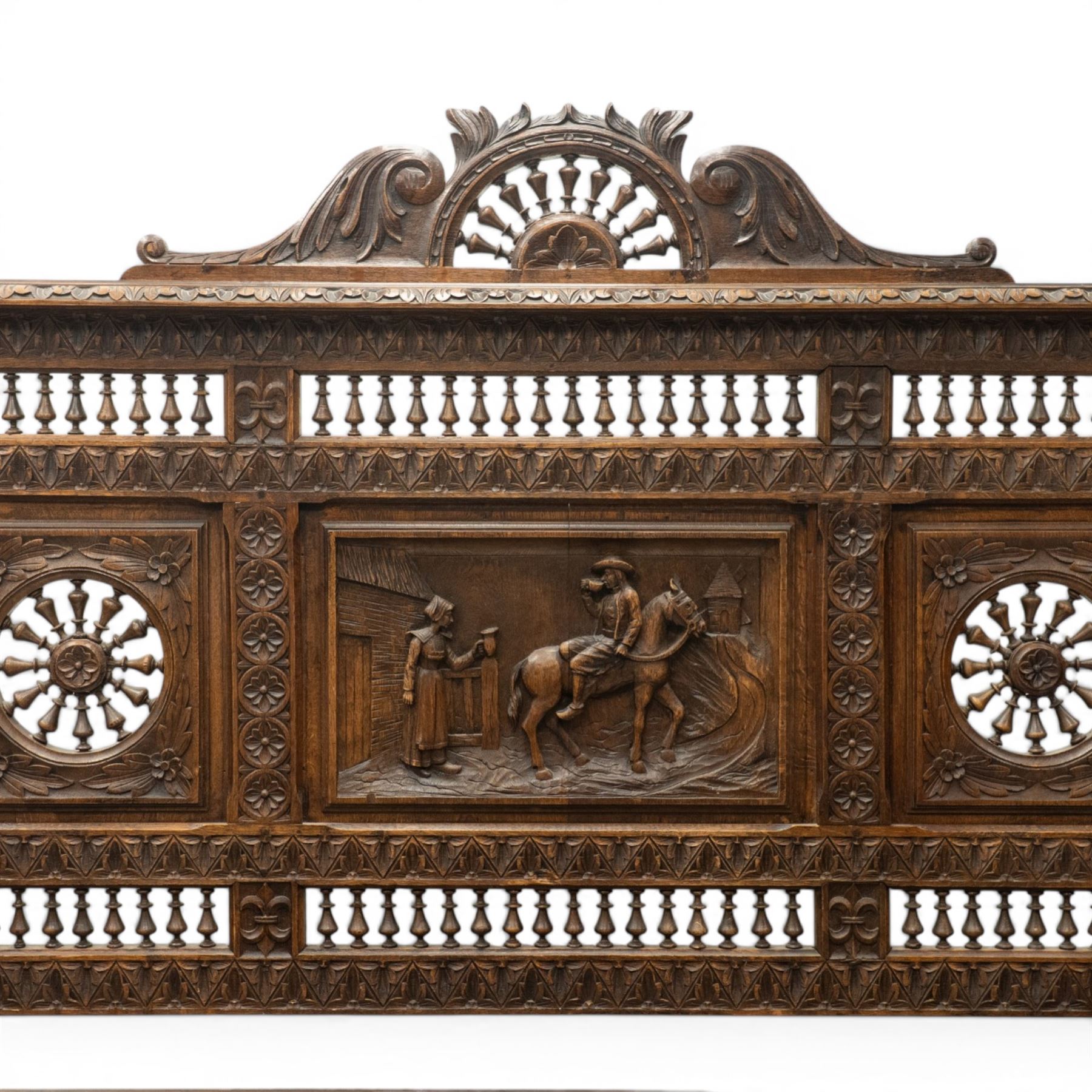 19th century European heavily carved oak hall settle, the impressive high-back with a pierced and carved acanthus pediment, over foliate and rosette carved back rails, flanking a central panel depicting a gentleman on horseback drinking, the hinged box seat over a quadruple panelled front with relief carved busts, lower moulded and carved edge on compressed bun feet