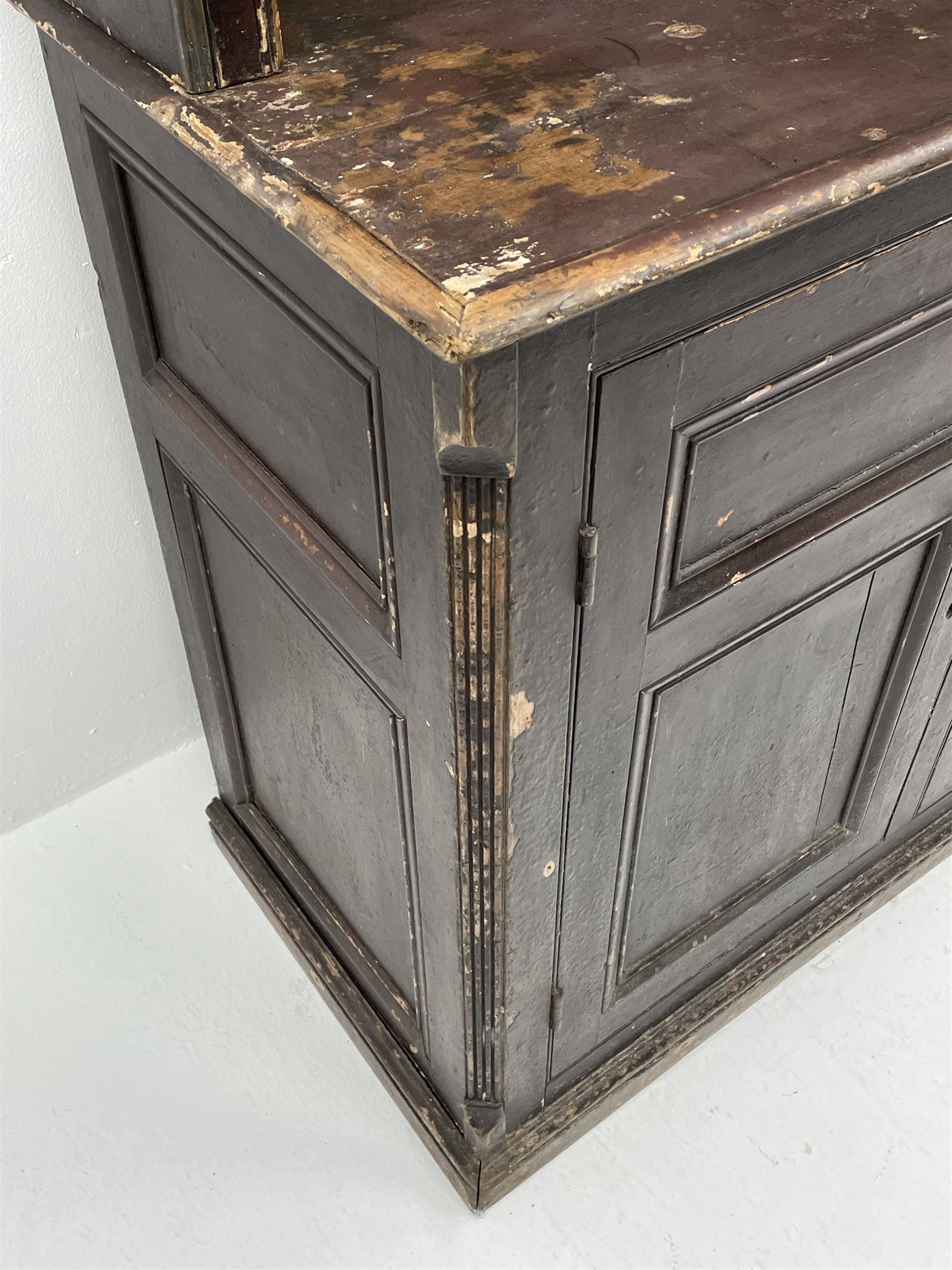 Early 19th century scumbled pine dresser, the projecting cornice over two heights plate rack with moulded frame, the base with reeded canted corners fitted with three drawers and two panelled cupboards, panelled sides, moulded skirt base