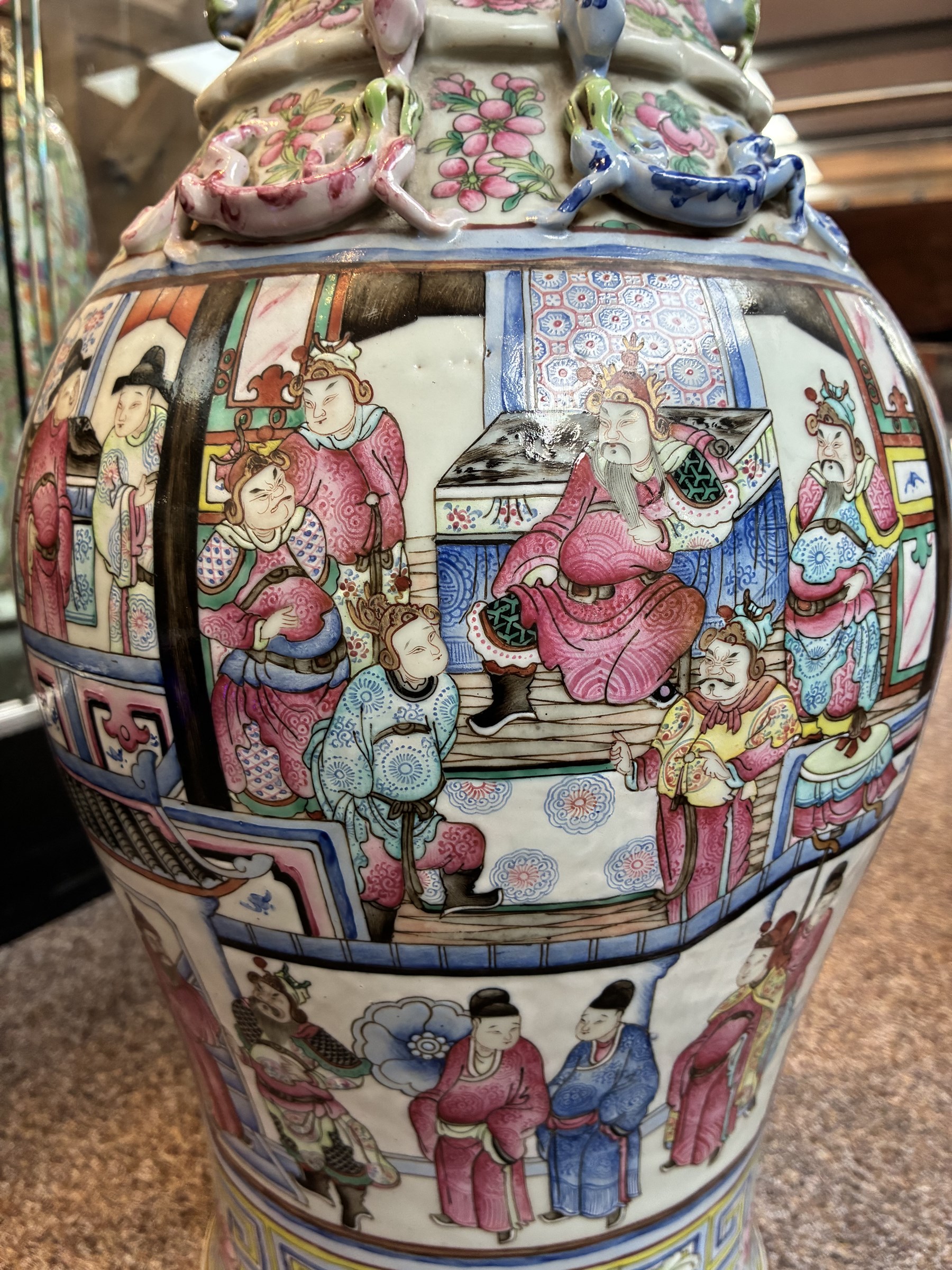 Large pair of 19th century Cantonese famille rose vases, each painted with various courtly scenes, including a display of warriors fighting on horseback before an official and his attendants, double Buddhist lion handles and applied at the shoulders with chilong, the lower band painted with Greek key motif, H58cm (2)