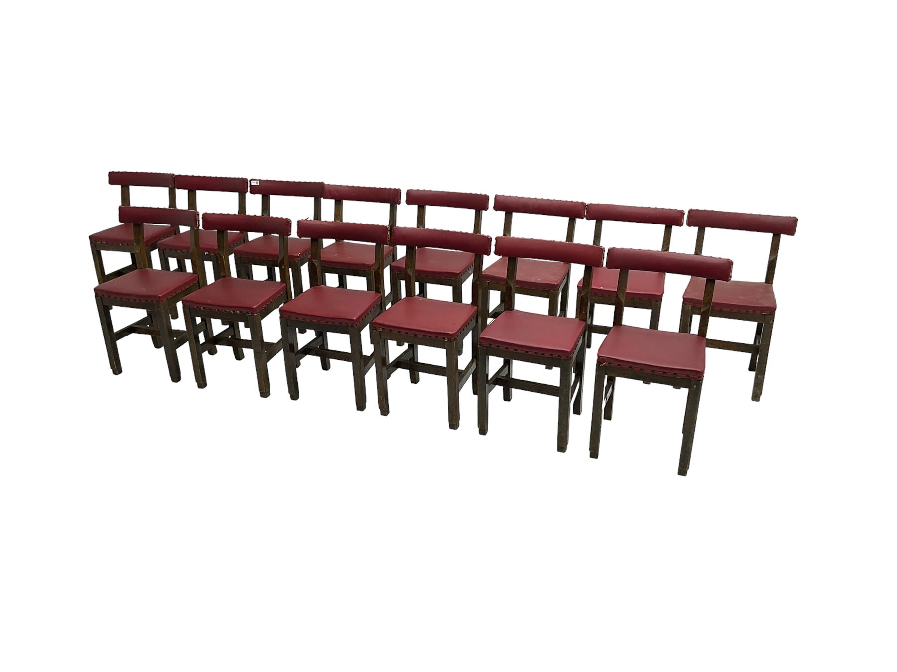 Set fifteen early 20th century oak school chairs, back rail and seat upholstered in claret red faux leather with studwork, raised on square supports united by H-stretcher (15)