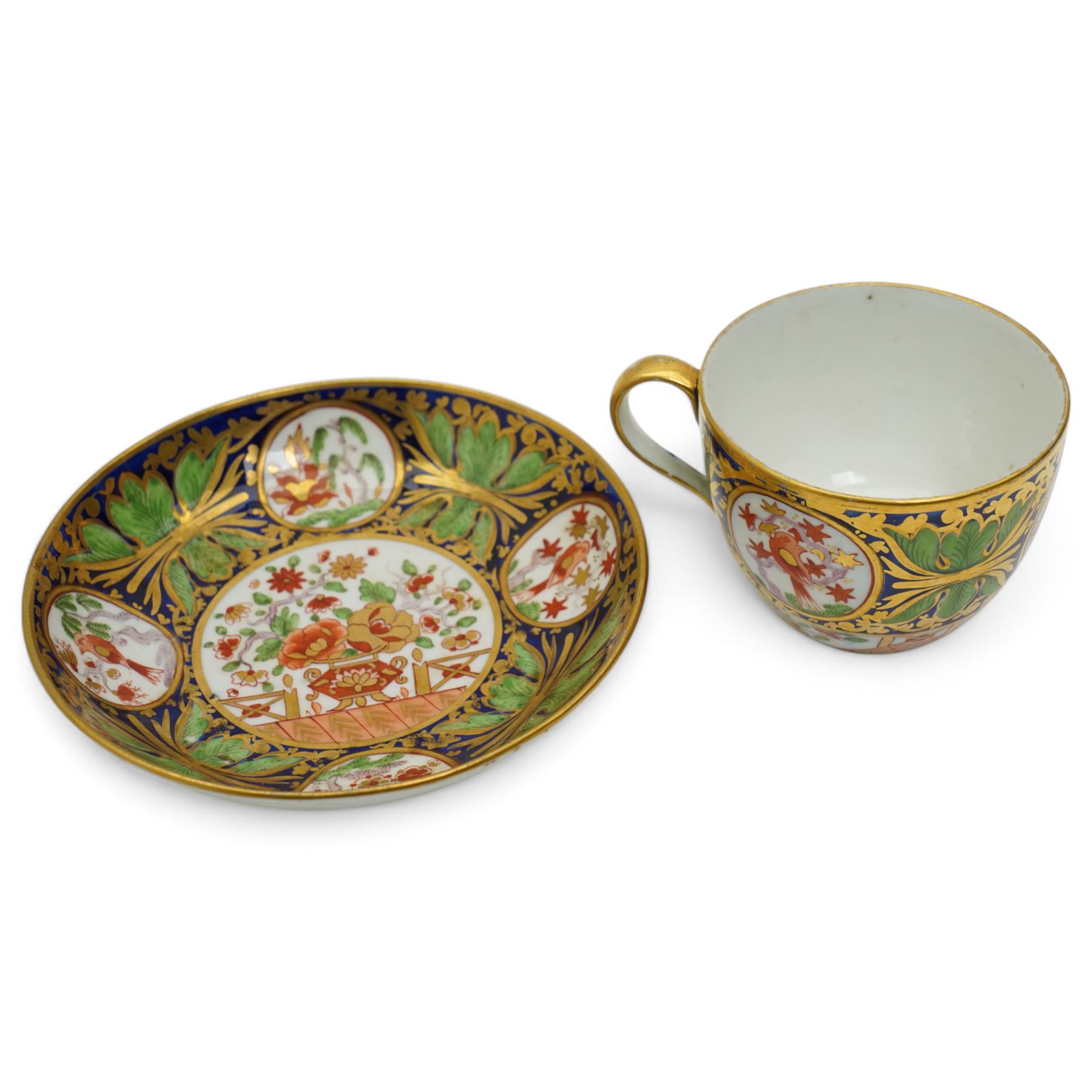 19th century teacup and saucer, possibly Coalport, decorated with panels of flowers on a cobalt blue ground with gilt decoration; together with two other teacup and saucer pairs, one with hand painted landscape decoration 