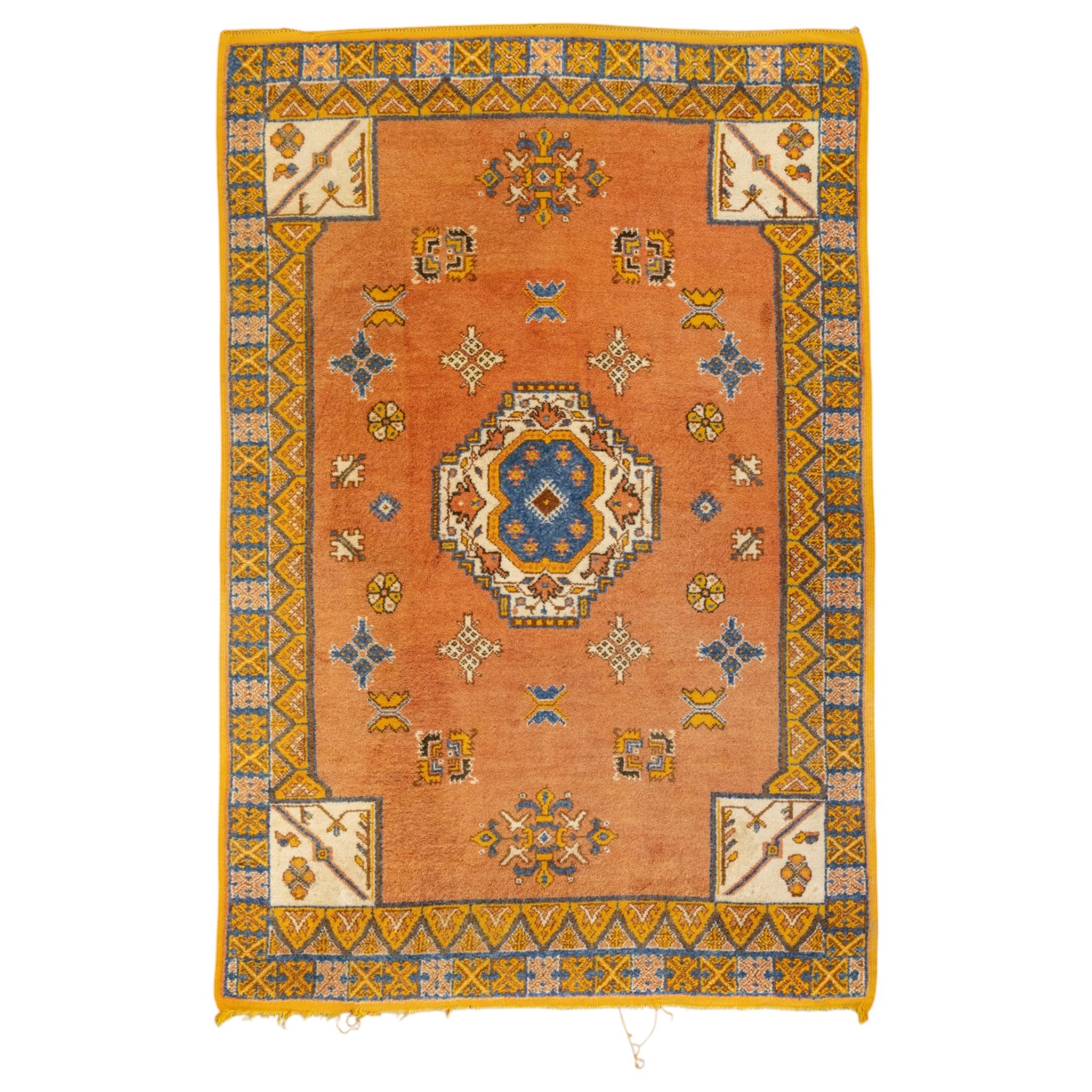 Turkish Anatolian hand-knotted carpet, salmon ground centred by a blue and cream octagonal medallion, scattered with geometric floral and tribal motifs, cream spandrels and yellow geometric border