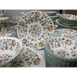 Minton Haddon Hall pattern tea and dinner wares, including basket dish, two covered tureens, six dinner plates, eight dessert plates, twelve tea plates, six soup bowls, six cereal bowls, teapot, coffee pot, milk jug, covered sucrier twelve tea cups and saucers, six mugs, footed bon bon dish, pair of candlestick holders, cake knife and slice etc (81)