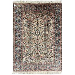 Persian design ivory ground rug, the field decorated with flower heads and trailing branches within pillars and cusped arches, the blue ground border with repeating floral design, within guard stripes 