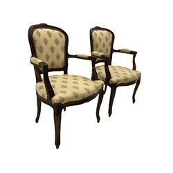 Pair French style beech framed open armchairs, the cresting rails carved with flower heads, upholstered in floral patterned fabric, on cabriole supports