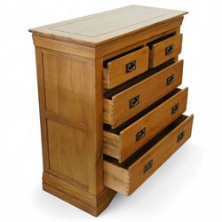 Contemporary solid oak five drawer chest, the rectangular top with inset panels over two short and three full-width drawers, all with brass-effect drop handles, raised on a plinth base