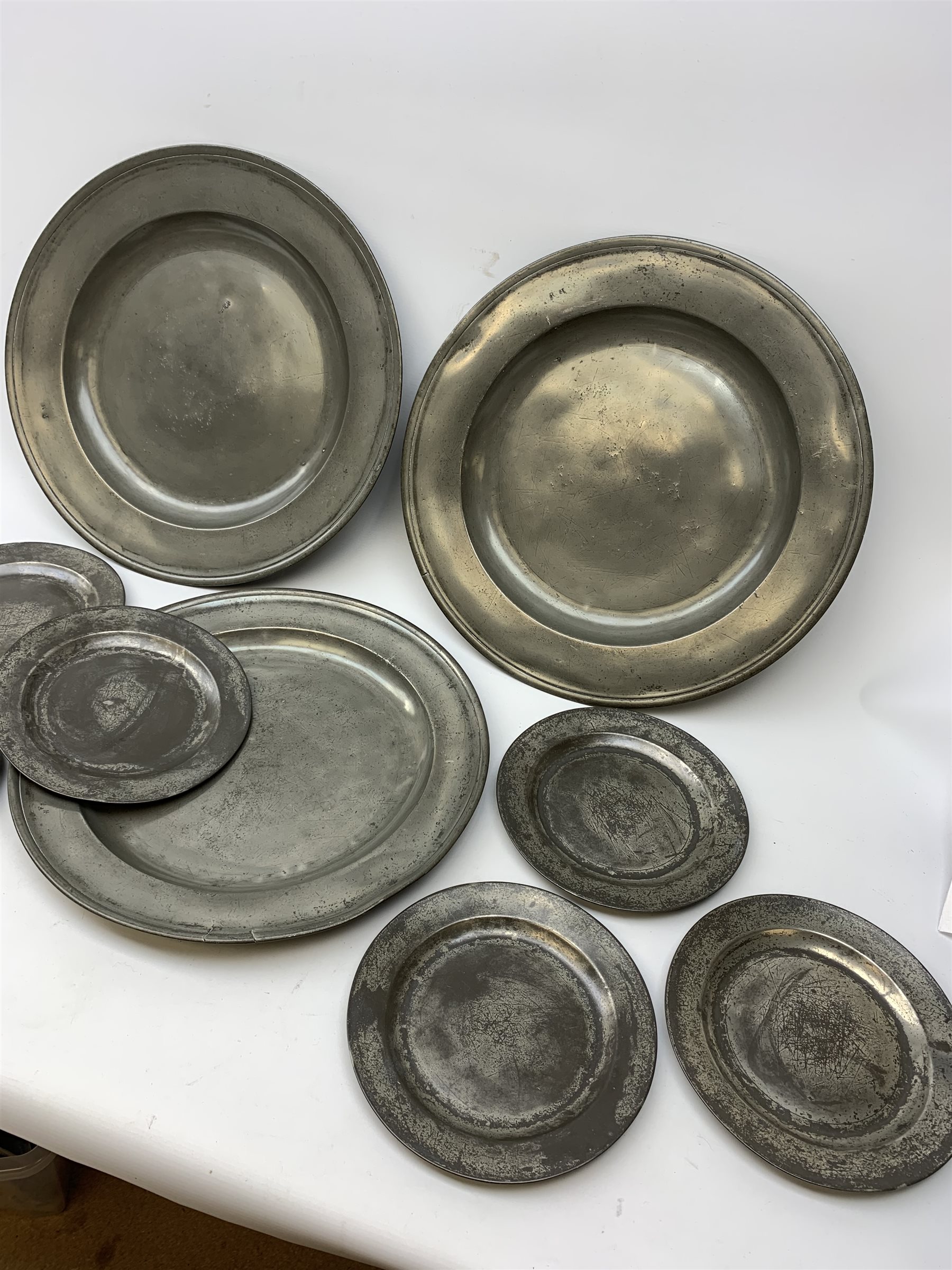 Collection of early 18th century pewter, comprising three large chargers, and seven plates, with various marks and touch marks verso, including the Crowned Rose and shield pseudo 'hallmarks', chargers D46cm and D42cm, plates D23cm.