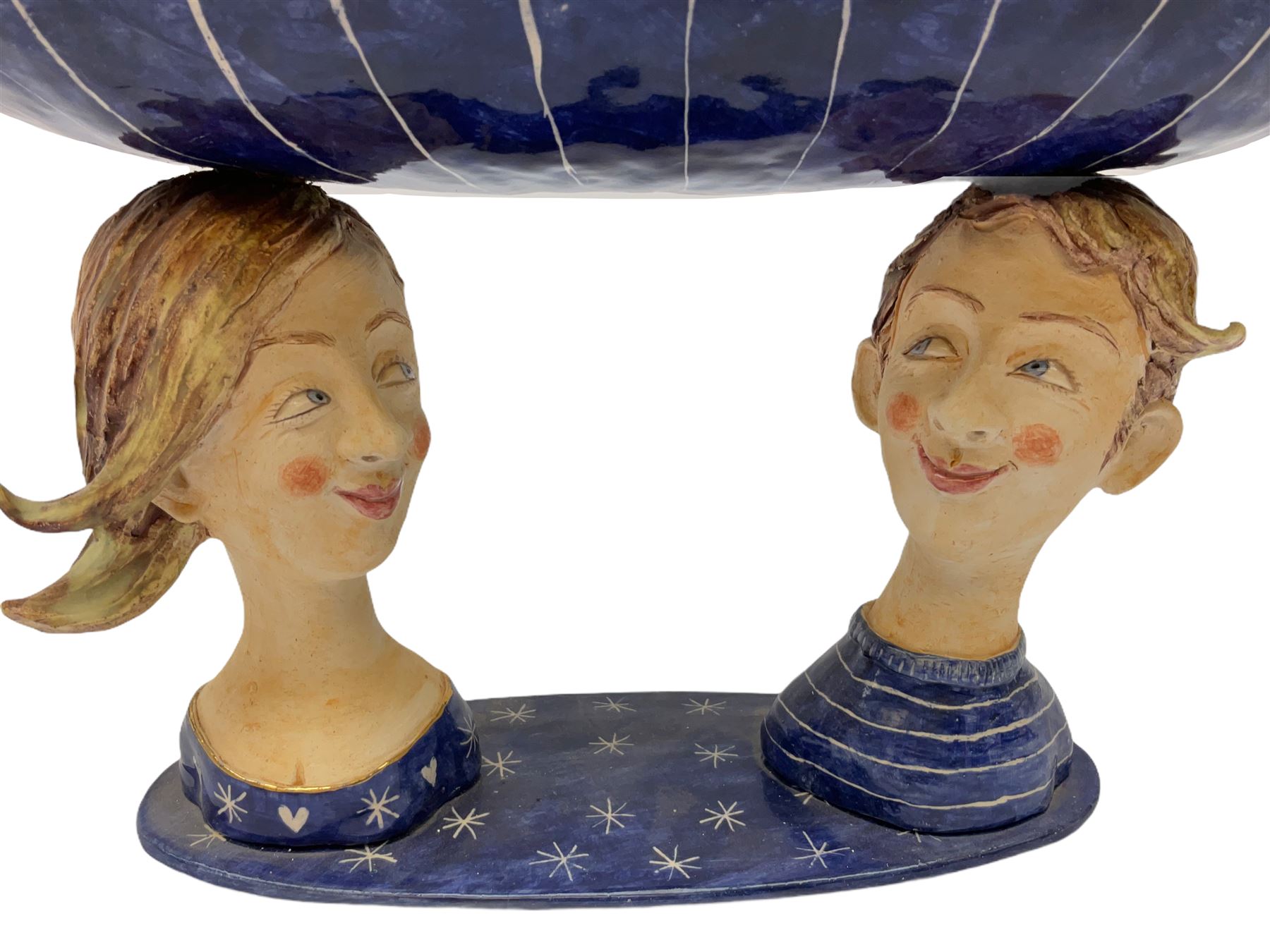 Ceramic 'girl and boy dish', by Helen Kemp, an oval dish with a mottled pink ground and gilt edging upon the sculpted heads of a girl and a boy, together with a 'boy sconce', by Helen Kemp, a sculpted boy holding a small bowl with foliate decoration, both with the artist's mark beneath.