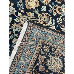 Persian Kashan indigo ground rug, the rosette medallion decorated with projecting palmettes, on a field of swirling leafy branches and decorated with further palmettes, the scrolling border with repeating stylised plant motifs, within floral pattern guard stripes