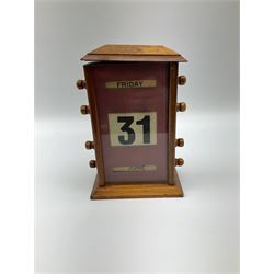 An early 20th century oak perpetual desk calendar, with three glazed apertures for day, date and month, H20cm