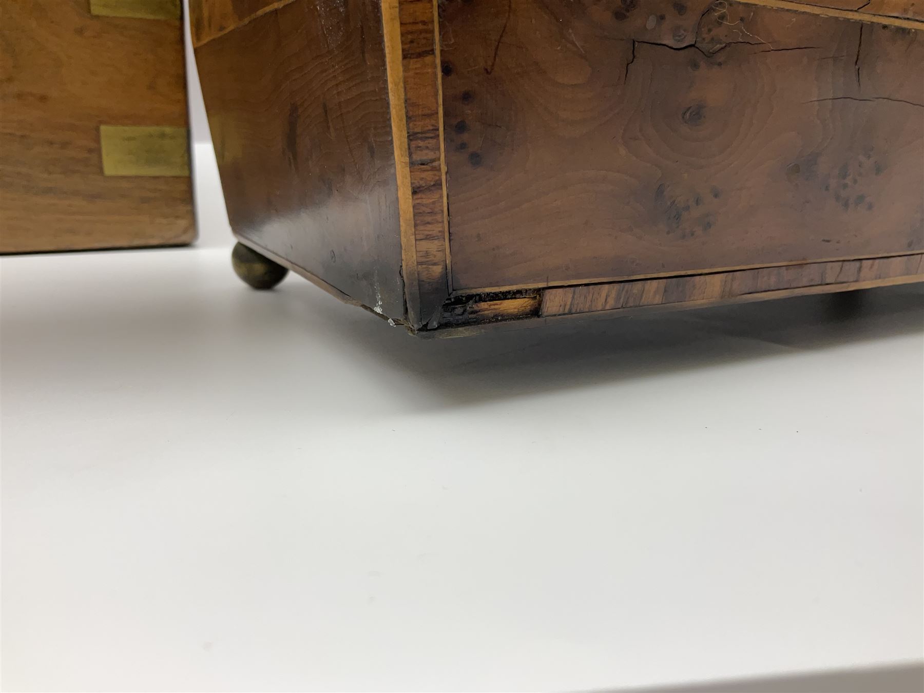 19th century burr yew wood tea caddy, of sarcophagus form, with strung details and brass mounts, the interior split into three compartments, upon four brass bun feet, together with an oak and brass bound writing slope, with red leather interior with gilt detailing, largest H16cm, W40cm