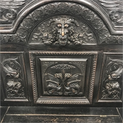  Victorian heavily carved oak settle, panelled back with gryphons and mask heads, lifting seat with lion carved arms above panelled inverted breakfront , W137cm, D50cm, H148cm  