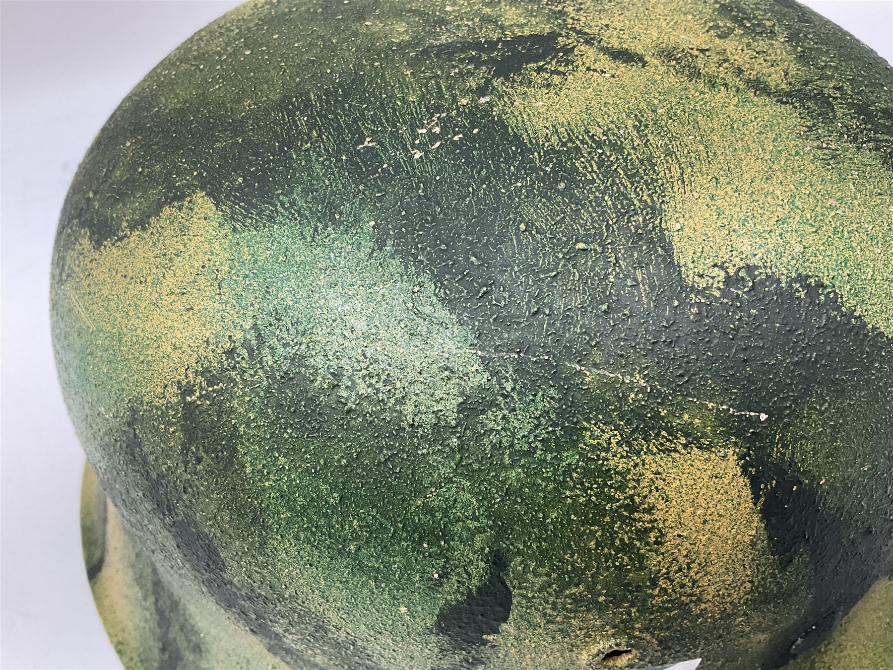 Fully restored German steel helmet, the camouflage painted exterior with two decals and replacement leather liner