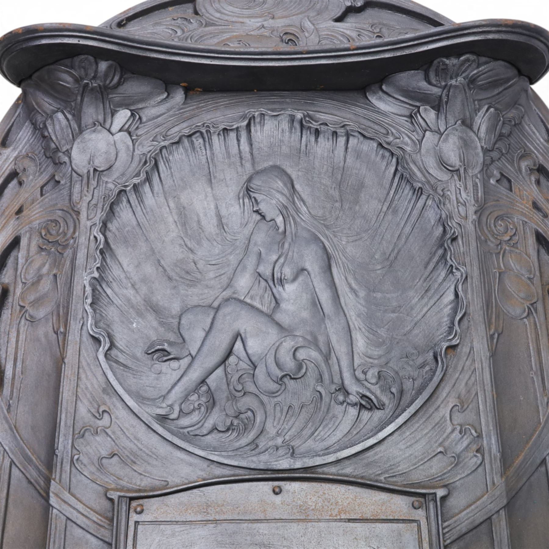 Art Nouveau cast iron fireplace, shaped hood with scrolling foliate crest, relief cast panel of female figure seated within shell form amidst wave motifs, uprights cast with foliate designs