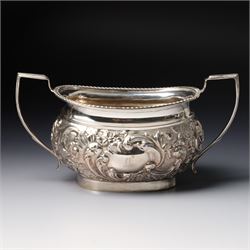 Late Victorian four piece silver tea set comprising teapot, coffee pot, sugar bowl and milk jug with embossed decoration, the cartouches engraved with an initial, the teapot and coffee pot Chester 1899 Maker George Nathan & Ridley Hayes, the sugar bowl and milk jug Birmingham 1899 Maker Thomas Hayes