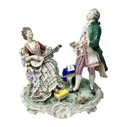 20th century Naples figure group, modelled as a seated female figure playing the lute seated, before a male figure stood holding a sheet of music, each in period dress, upon an oval base with gilt heightened scroll edge, with crowned N mark beneath, H31.5cm L33cm
