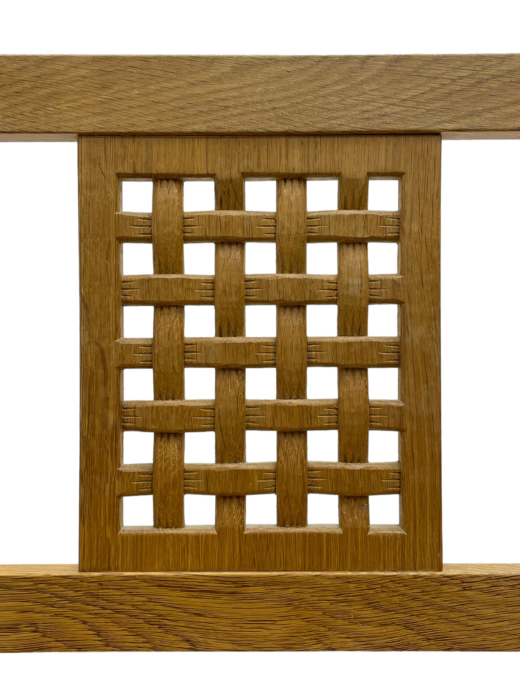 Mouseman - oak carver elbow chair, pierced and carved lattice back over leather upholstered seat with stud band, on octagonal supports united by plain stretchers, carved with mouse signature, by the workshop of Robert Thompson, Kilburn 