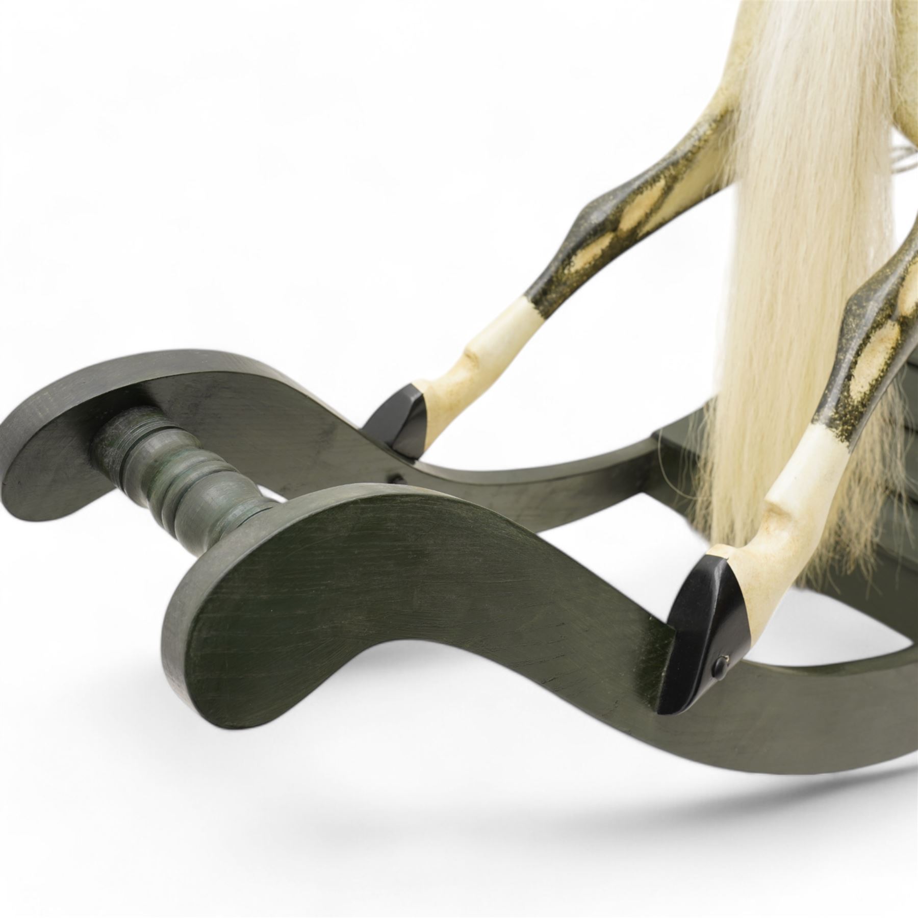 In the manner of F. H. Ayres - large carved wooden rocking horse, in dapple grey paint finish, decorated with glass eyes, leather reins, stirrup and saddle, on bowed rockers united by turned stretchers and boarded base 