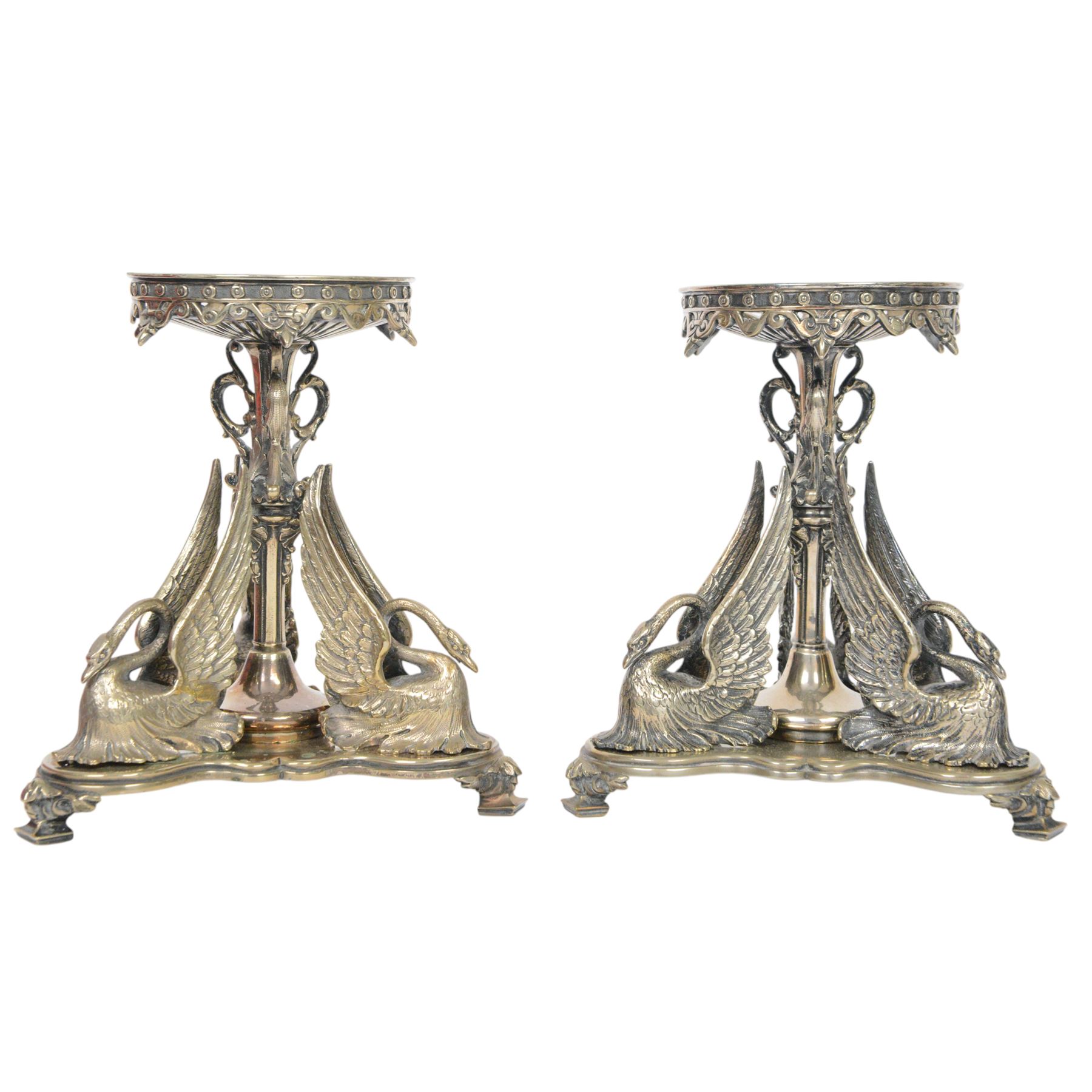Pair of late 19th century silver plated tazza or centre piece stands, each of trefoil form upon acanthus mounted square pad feet, rising to a central decorative stem flanked by three stylised swans, the open foliate scrolling upper section supporting a circular plate stand, H19cm