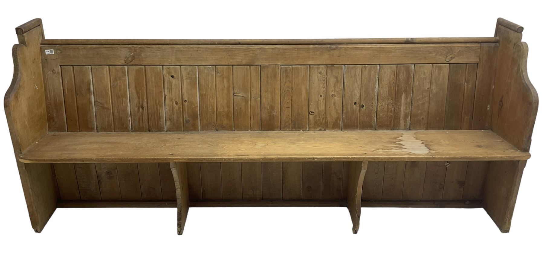Early 20th century pine church pew, vertical plank back over rectangular seat, flanked by shaped end supports, with bible rest to back
