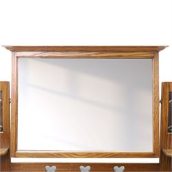 Shapland & Petter - oak mirrored dressing chest, tilted mirror flanked by tulip carved supports, shaped shelves with heart cut outs, above two short over one long drawers, with brass handles and stamped S & P on the locks, raised on shaped supports