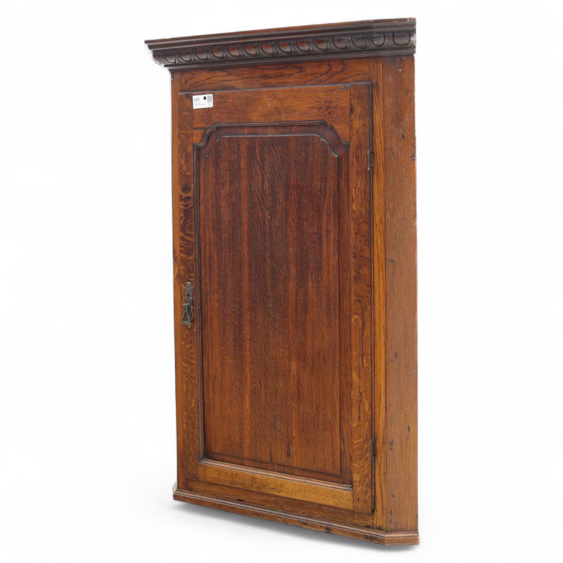 19th century oak wall hanging corner cupboard, moulded cornice above a panelled door enclosing shaped interior shelves, finished in green paint to the backboards