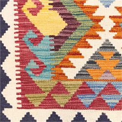 Afghan Chobi flatweave kilim with a repeating stepped diamond medallion design in ivory, green, rust, teal, purple, indigo and framed by chevron and geometric borders