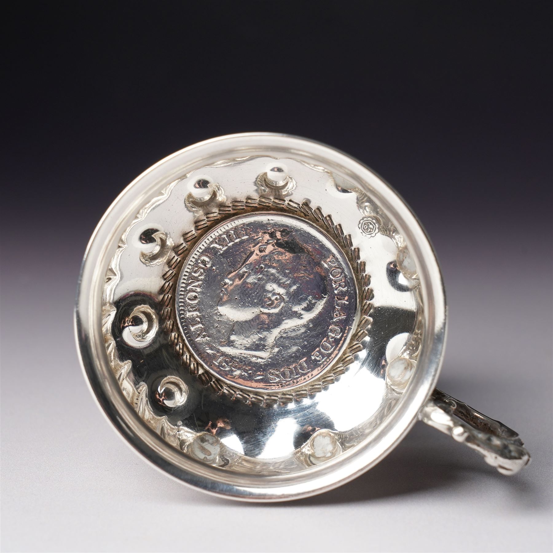 French silver tasse de vin with Minerva's head and makers mark J.P. with an anchor, the rim engraved C Mouly, Spanish tasse de vin inset with a silver coin and two other tasse de vin (4)