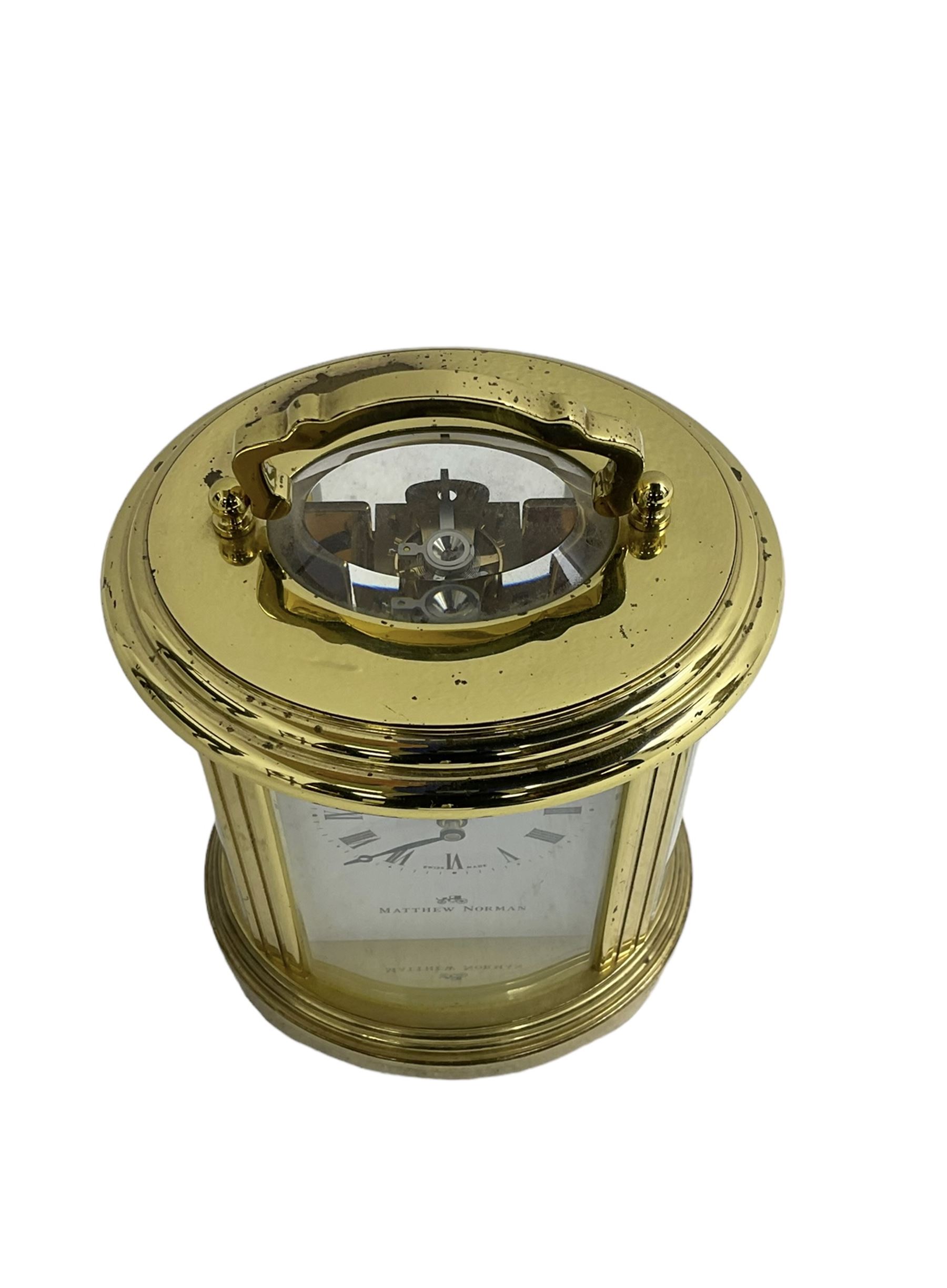 English - 20th century  8-day oval carriage clock, in a polished gilt case with an enamel dial, Roman numerals and moon hands, dial inscribed Mathew Norman, London, timepiece spring driven movement with a lever platform escapement, balance with timing screws. 