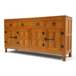 Lizardman - oak 5' sideboard, rectangular top over three panelled frieze drawers, fitted with two double panelled cupboards with wrought iron handles and locks, raised on tapered octagonal feet, with carved lizard signature, by Derek Slater of Crayke