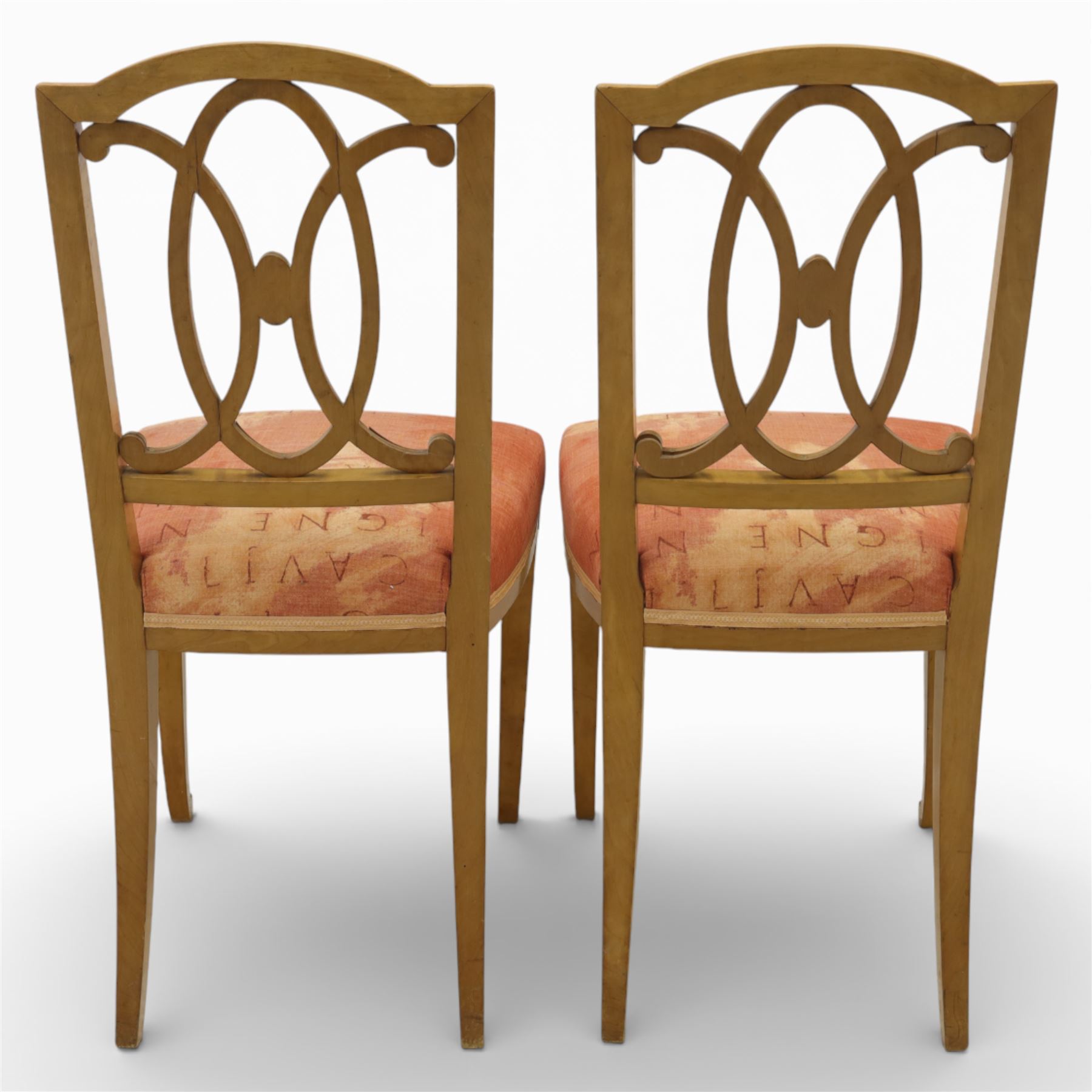 Edwardian pair of satinwood side chairs, each with shaped crest rail above an intertwining oval pierced splats centred by a floral patera, upholstered drop-in seats, raised on cabriole supports with applied floral mounts to the knees