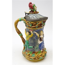  Victorian Minton Majolica 'Tower' flagon, with Jester finial, the body relief moulded with mediaeval dancing figures & hinged pewter lid, impressed marks to base, H33.5cm  