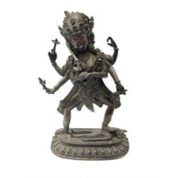 Eastern Bronzed figure modelled as the deity Kali with eight arms and three faces stood on shiva's chest, upon stylised locus base H28cm