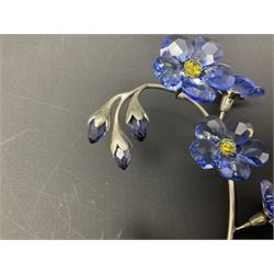 Eleven Swarovski Crystal flowers, to include violet, sunflower, delphinium, forget-me-not and lily-of-the-valley, each on stylised metal stems, tallest H23cm