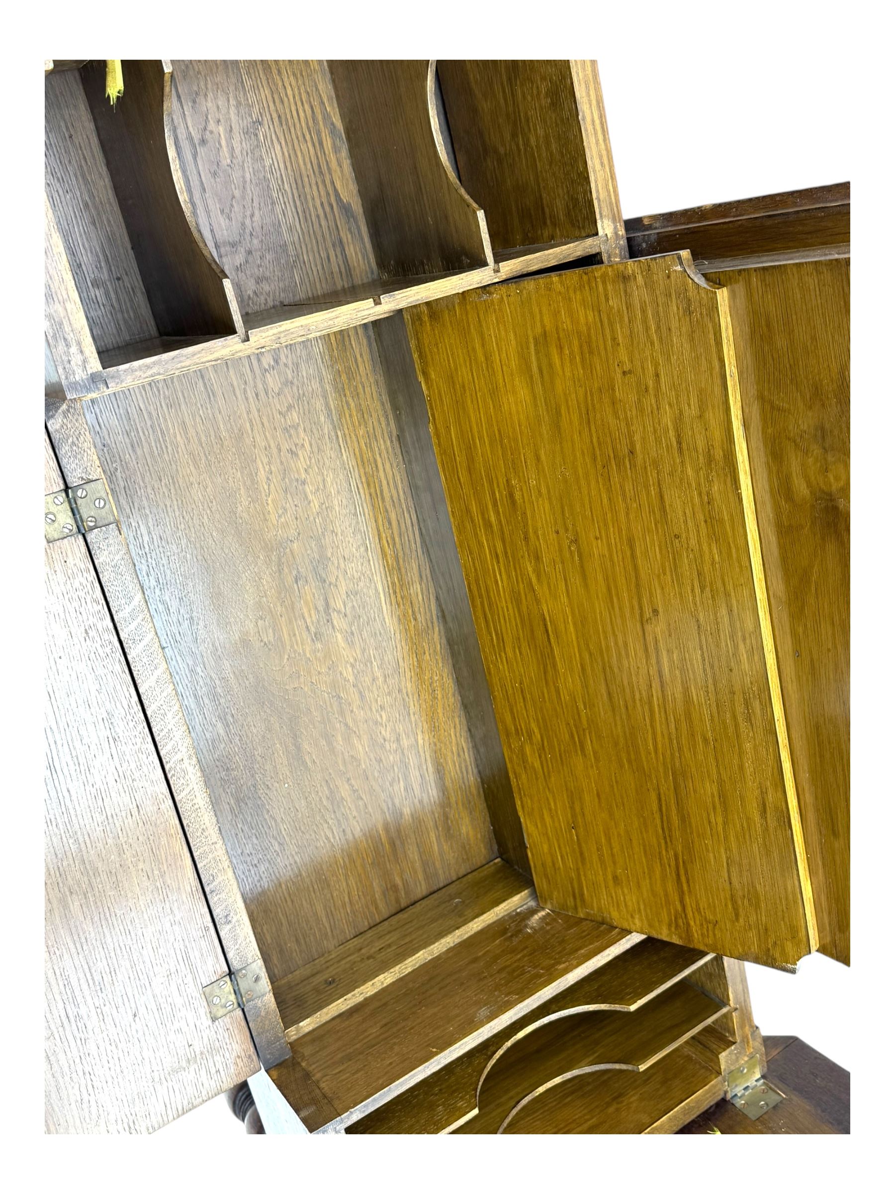 Edwardian oak metamorphic 'Britisher Writing Table', rectangular hinged top revealing correspondence compartments and hinged writing surface with underside storage, flanked by twin hinged compartments with dividers, on turned supports