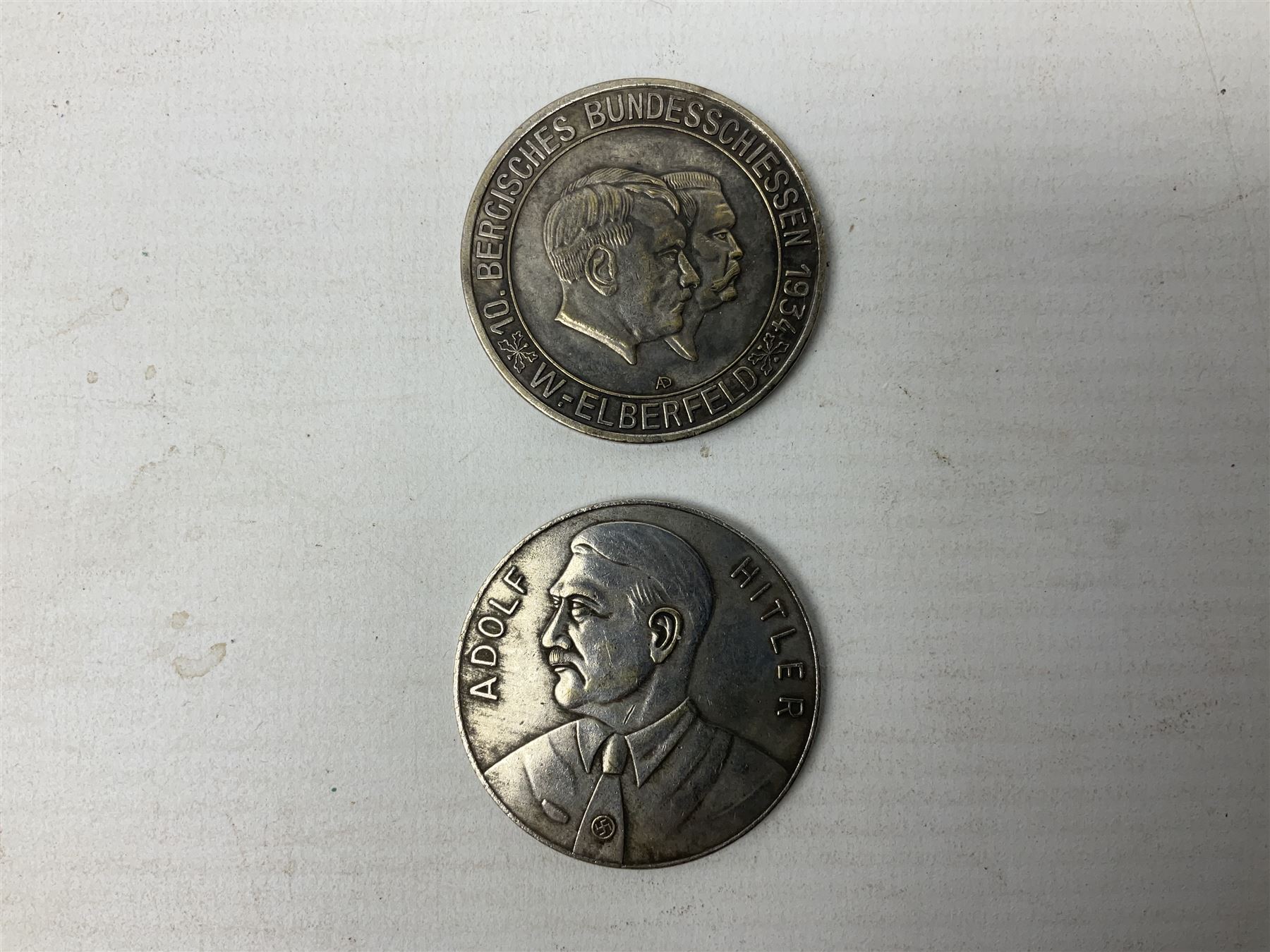 Four post-WW2 'silver' medallions of Adolf Hitler/German interest, two depicting Von Hindenburg also; and pair of 1960s trench art shell case bases as ashtrays mounted with Libyan Five Milliemes coins as cigarette rests (6)