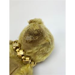 Early 20th century English teddy bear, with wood wool filled body with jointed limbs, felt covered paw pads, five claw stitching to feet and elongated arms with spoon shaped paws H14