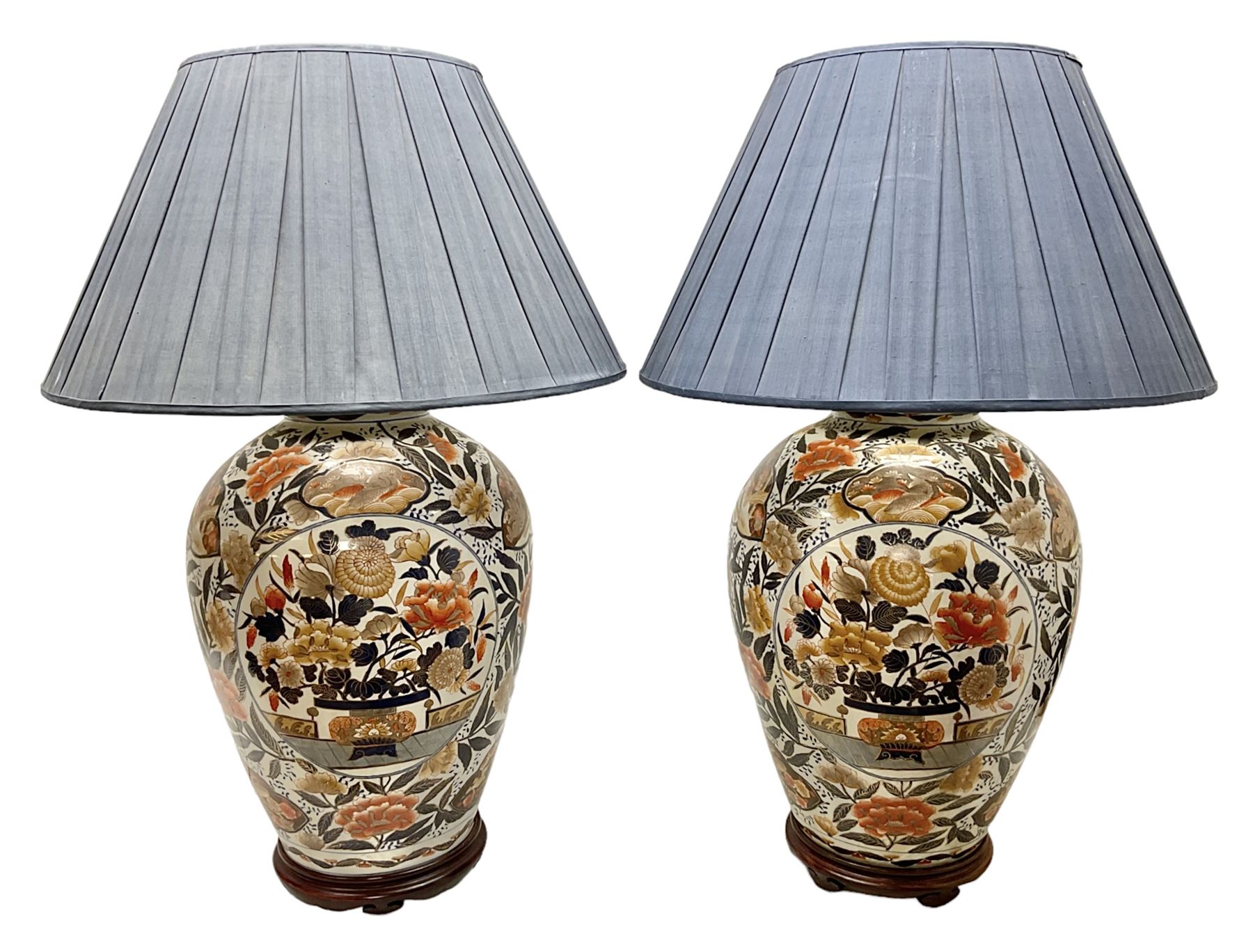 Pair of large and impressive 20th century Japanese Imari table lamps, each of ovoid form, decorated in the Imari palette with roundels containing flowering urns, and shaped panels of birds, set against a white ground decorated with blossoming peonies, lamp base (not including fixtures) H56.5cm overall including shade H89cm