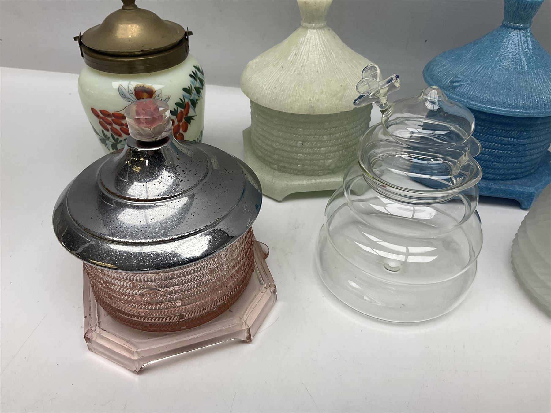 Collection of glass beehive honey pots, to include a blue slag example, milk glass, pink, green, etc together with four white metal examples (16) 