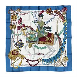 Hermès 'Le Timbalier' silk scarf, designed by Francoise Heron in 1961, printed with a central image of a gentleman on horseback donning extravagant dress, on white ground surrounded with colourful stylised knotted ropes, contained within peacock blue border, with rolled hand stitched edges and Hermes material label, 87cm square